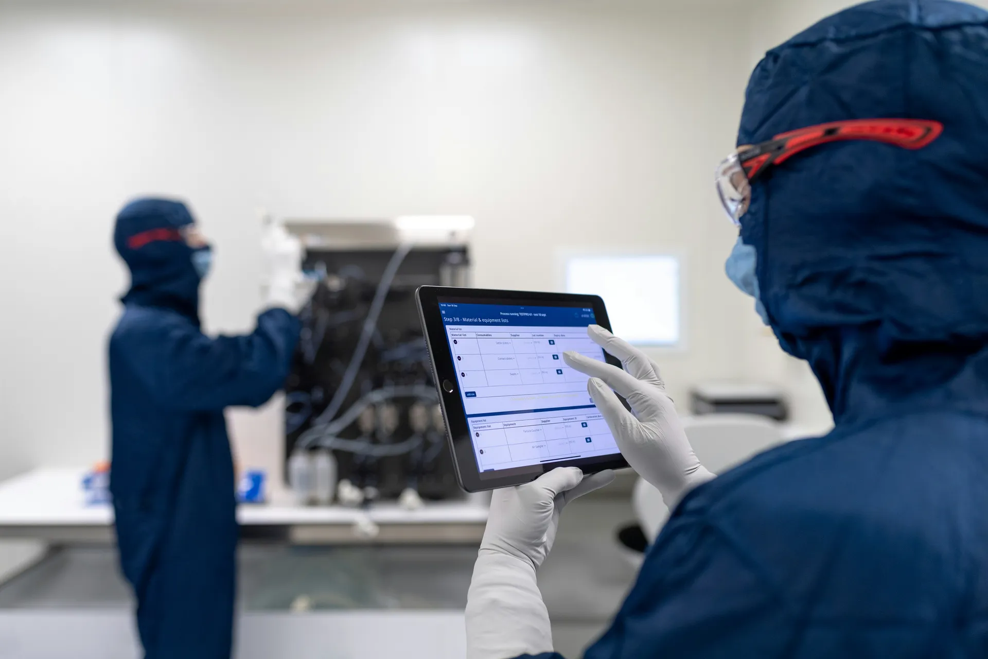 Cleanroom technician with tablet running equipment checklist